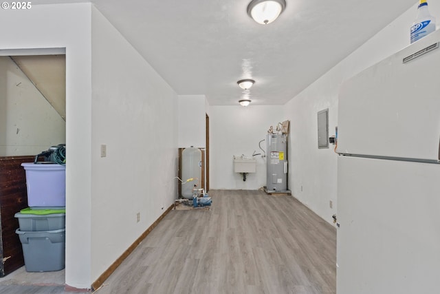 272 Whipple Tree Dr, Yoncalla, OR 97499 - below grade area featuring freestanding refrigerator, wood finished floors, electric water heater, electric panel, and a sink
