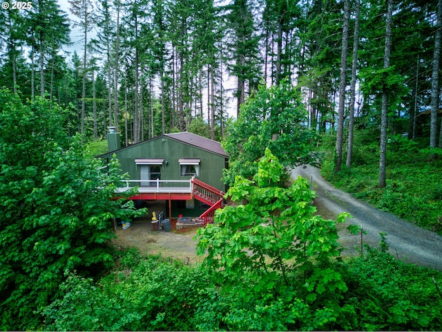 272 Whipple Tree Dr, Yoncalla, OR 97499 - rear view of house with a deck, a view of trees, and a chimney