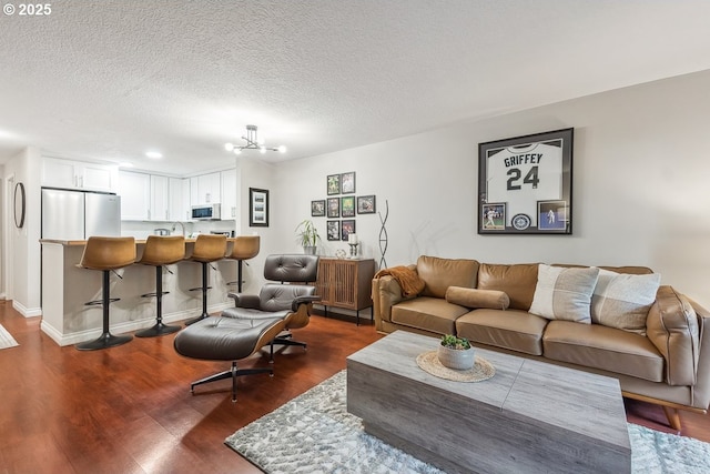 4880 SW Scholls Ferry Rd Unit 14, Portland, OR 97225 - living area featuring dark wood-type flooring, a textured ceiling, baseboards, and a chandelier