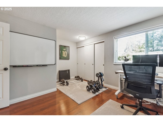 office space with baseboards, a textured ceiling, and wood finished floors