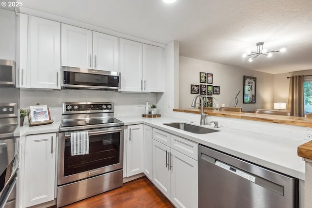 4880 SW Scholls Ferry Rd Unit 14, Portland, OR 97225 - kitchen featuring a sink, appliances with stainless steel finishes, white cabinets, and light countertops