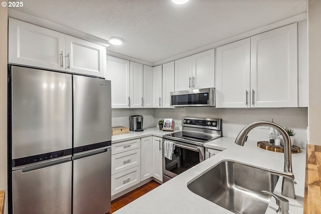 4880 SW Scholls Ferry Rd Unit 14, Portland, OR 97225 - kitchen with a sink, white cabinetry, appliances with stainless steel finishes, and light countertops