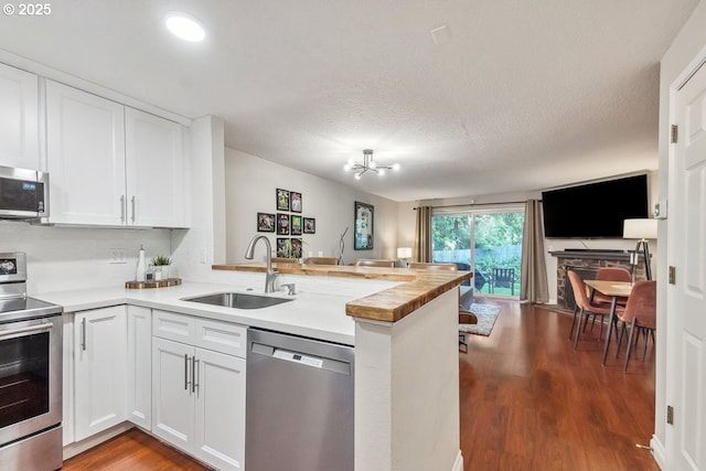 4880 SW Scholls Ferry Rd Unit 14, Portland, OR 97225 - kitchen with stainless steel appliances, open floor plan, a sink, and a peninsula
