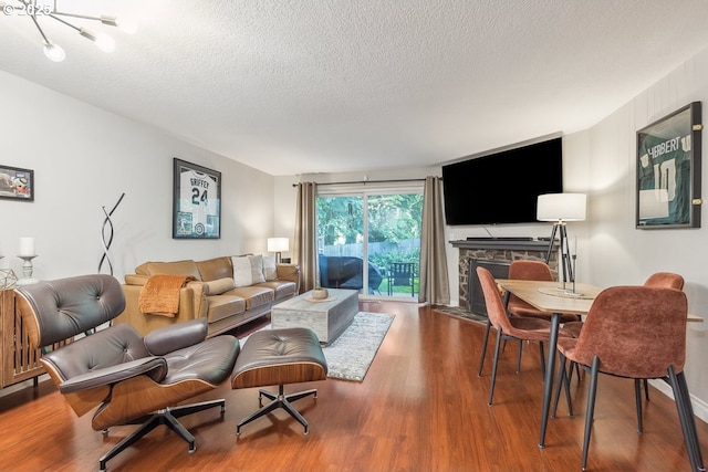 4880 SW Scholls Ferry Rd Unit 14, Portland, OR 97225 - living room with an inviting chandelier, a textured ceiling, wood finished floors, and a fireplace