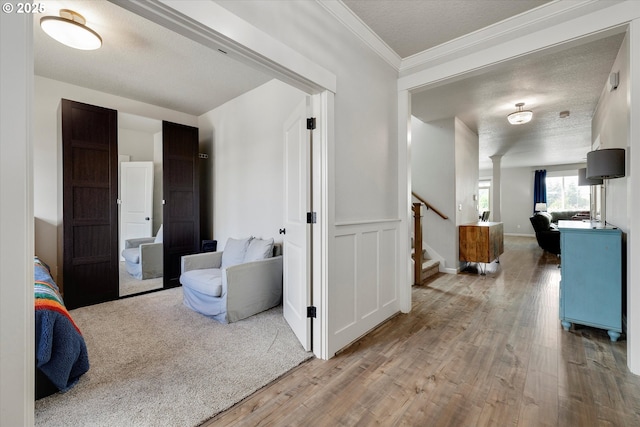 12241 Mimosa Way, Oregon City, OR 97045 - hallway with wood finished floors, stairway, crown molding, a textured ceiling, and wainscoting