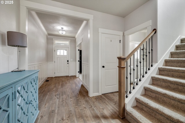 12241 Mimosa Way, Oregon City, OR 97045 - entrance foyer featuring stairs, crown molding, wood finished floors, and a wainscoted wall