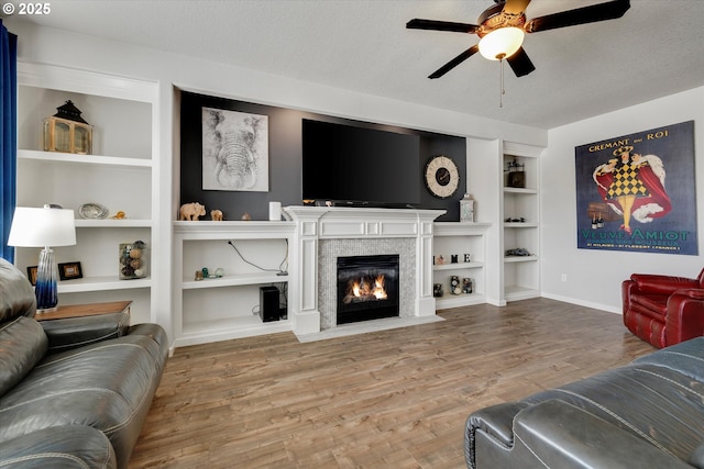 12241 Mimosa Way, Oregon City, OR 97045 - living area featuring a ceiling fan, built in features, a fireplace with flush hearth, and wood finished floors