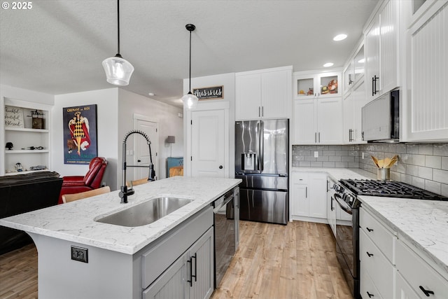 12241 Mimosa Way, Oregon City, OR 97045 - kitchen with stainless steel appliances, light wood-style flooring, white cabinets, pendant lighting, and backsplash