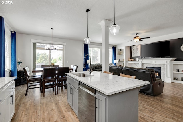 12241 Mimosa Way, Oregon City, OR 97045 - kitchen with dishwasher, a premium fireplace, ceiling fan, light wood-style flooring, and light stone counters