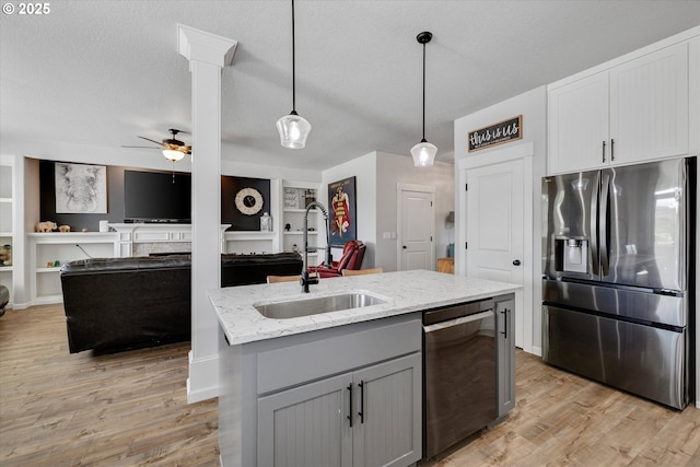 12241 Mimosa Way, Oregon City, OR 97045 - kitchen with stainless steel appliances, open floor plan, light stone countertops, a ceiling fan, and a textured ceiling
