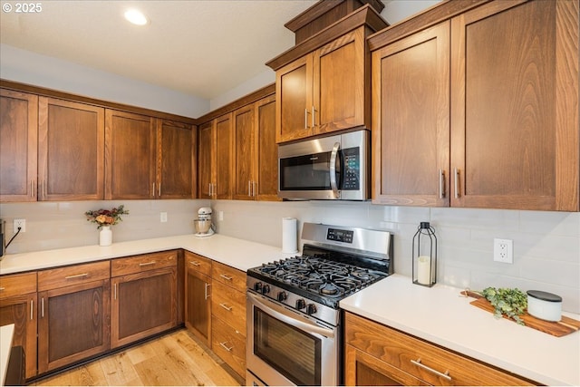 2341 Turnbull Ct, Forest Grove, OR 97116 - kitchen with appliances with stainless steel finishes, tasteful backsplash, light countertops, light wood-type flooring, and recessed lighting