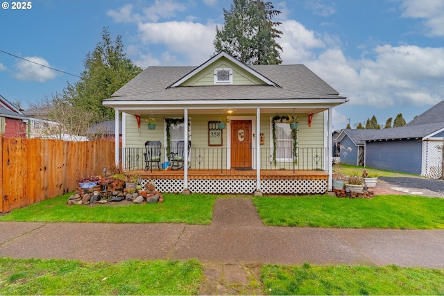 bungalow-style house featuring covered porch and a front yard