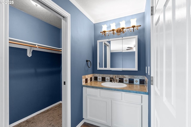bathroom with vanity, baseboards, and a spacious closet