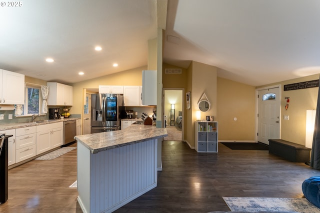 kitchen with a kitchen island, stainless steel appliances, dark wood-type flooring, and white cabinets