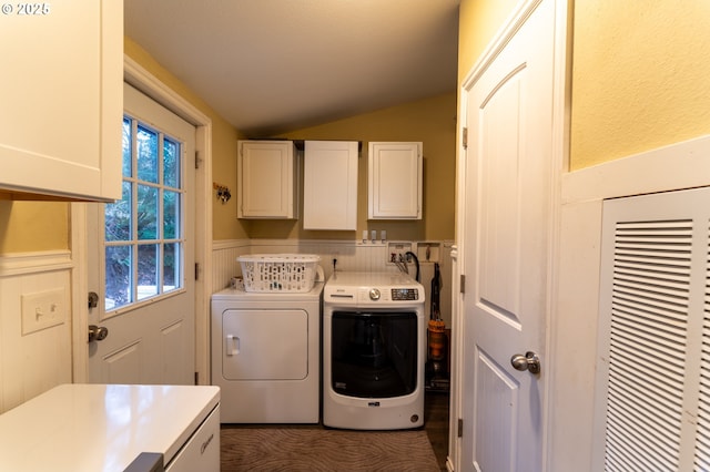 clothes washing area with washer and dryer and cabinets