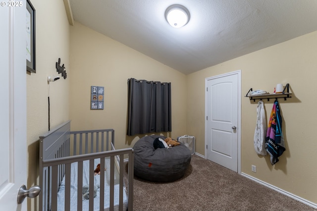 carpeted bedroom with a crib and lofted ceiling