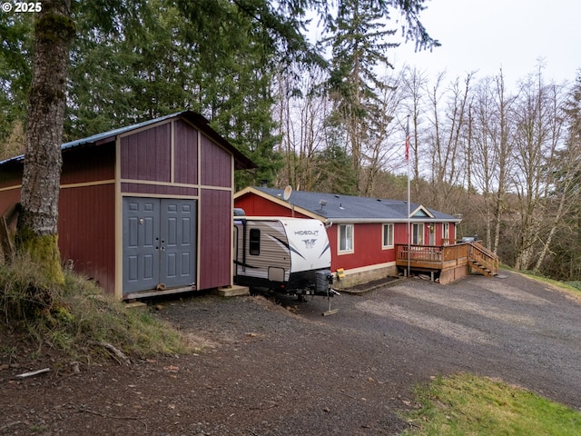 view of front of house with a storage shed and a wooden deck