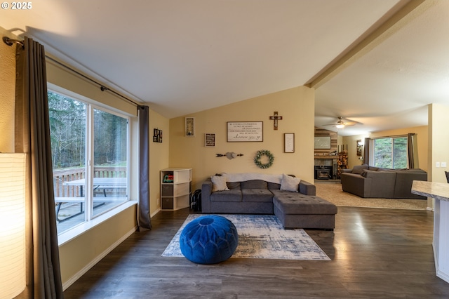 living room featuring ceiling fan, dark wood-type flooring, lofted ceiling, and plenty of natural light