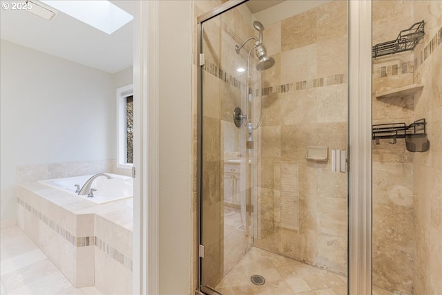 bathroom featuring a shower stall, a skylight, and a bath