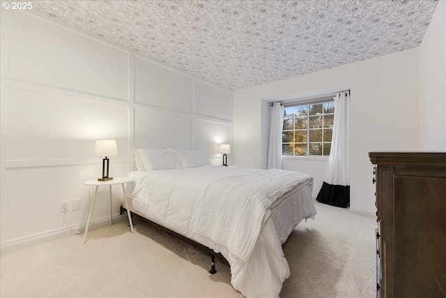 carpeted bedroom featuring a textured ceiling and a decorative wall