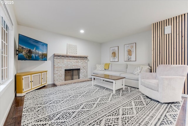 living room featuring recessed lighting, a brick fireplace, baseboards, and wood finished floors