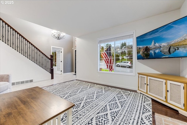 entryway featuring stairway, baseboards, visible vents, and a chandelier