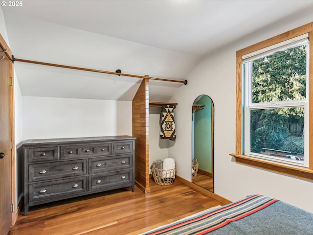 unfurnished bedroom featuring hardwood / wood-style flooring and vaulted ceiling