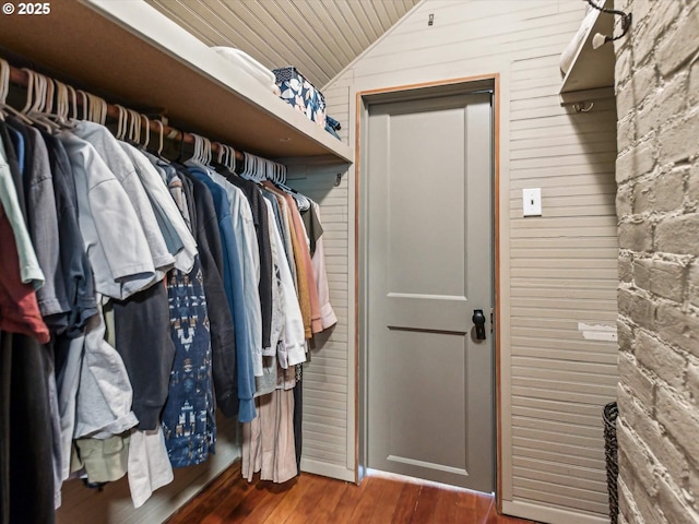 spacious closet with vaulted ceiling and dark hardwood / wood-style flooring