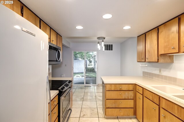 15000 SW Farmington Rd Unit 51, Beaverton, OR 97007 - kitchen with stainless steel appliances, a peninsula, light countertops, light tile patterned flooring, and recessed lighting
