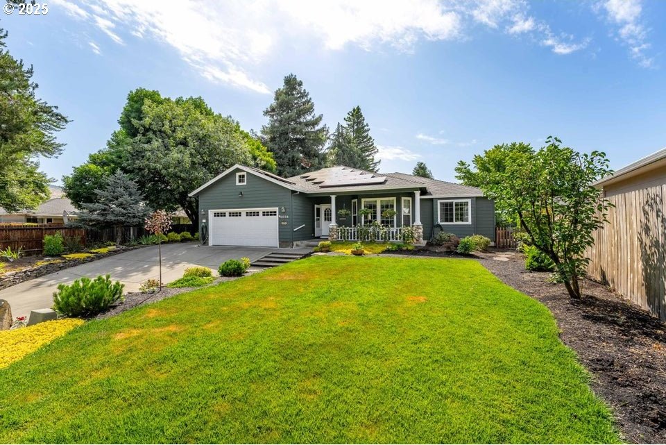2556 Waters Edge Way, Medford, OR 97504 - single story home featuring roof mounted solar panels, a garage, driveway, and covered porch