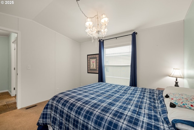 carpeted bedroom featuring visible vents, vaulted ceiling, and a notable chandelier