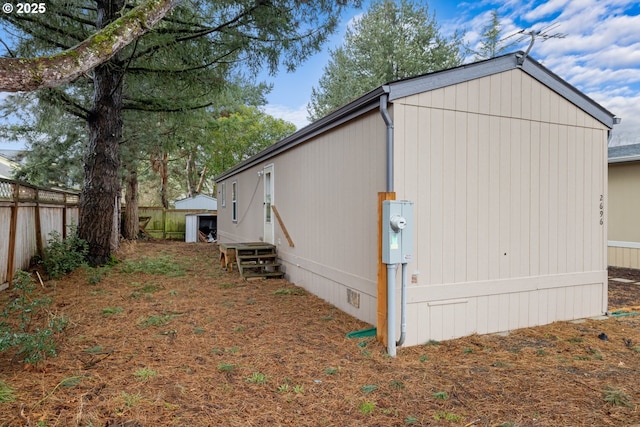 view of side of property with crawl space and fence