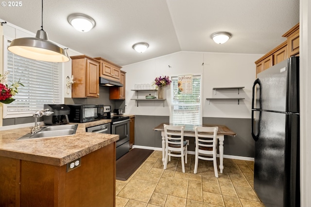 kitchen featuring brown cabinetry, pendant lighting, a sink, and black appliances