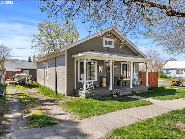 view of front of property with a porch and a front lawn