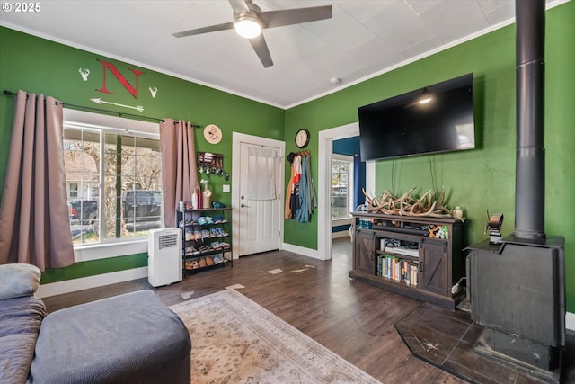 living room featuring baseboards, ceiling fan, ornamental molding, and wood finished floors