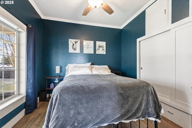 bedroom featuring crown molding, dark wood-style flooring, a ceiling fan, and a closet