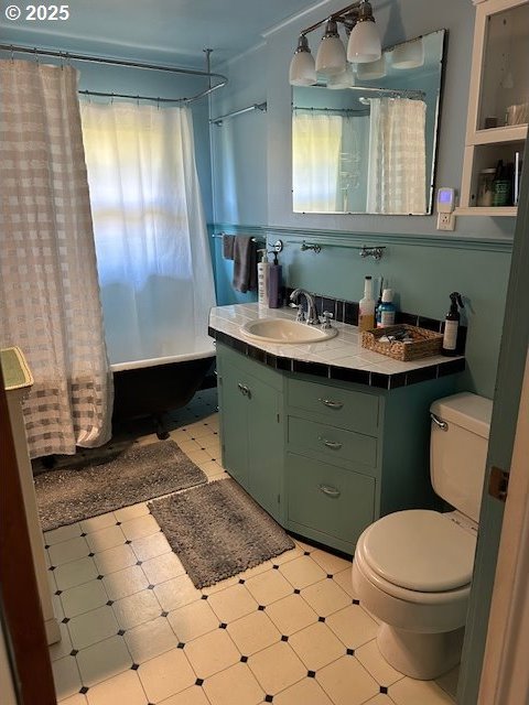 full bath featuring vanity, shower / tub combo with curtain, tile patterned floors, and toilet