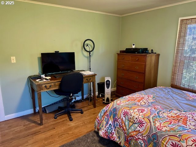 bedroom featuring crown molding, baseboards, and wood finished floors