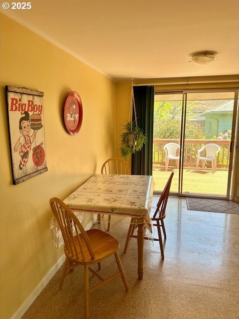 dining space featuring crown molding and baseboards