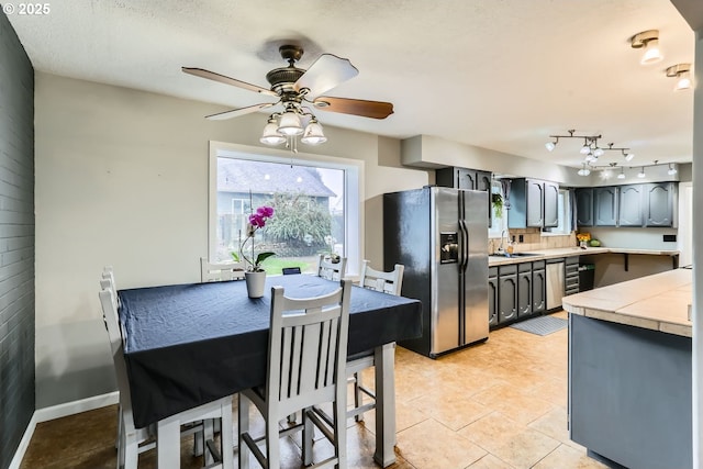 kitchen with backsplash, ceiling fan, sink, light tile patterned floors, and stainless steel fridge with ice dispenser