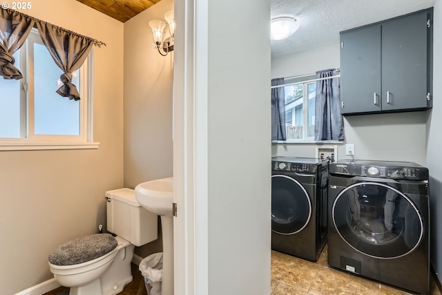 clothes washing area with separate washer and dryer and a textured ceiling