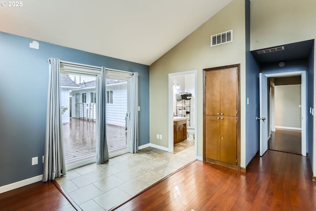 doorway featuring light hardwood / wood-style flooring and vaulted ceiling