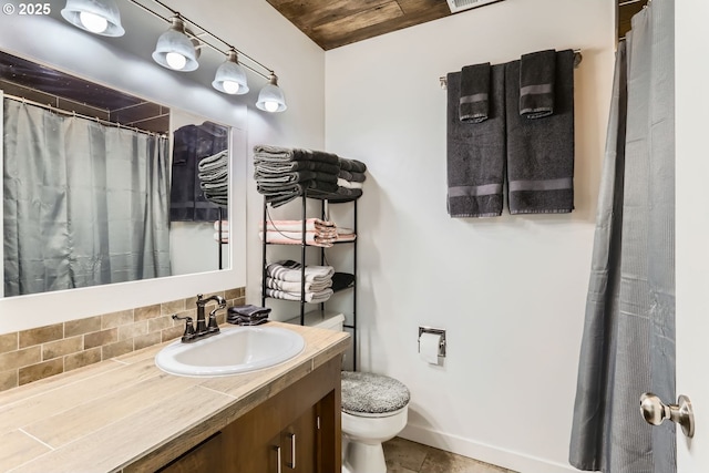 bathroom featuring decorative backsplash, vanity, and toilet