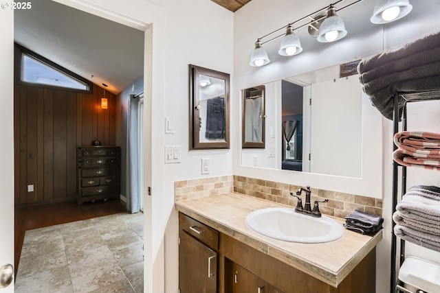 bathroom featuring vanity, tasteful backsplash, and vaulted ceiling