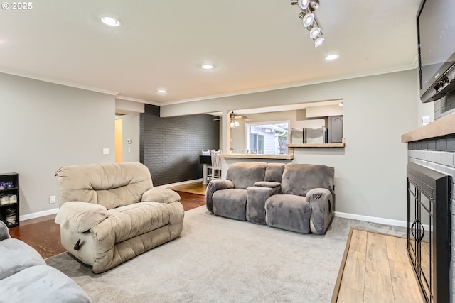 living room with a fireplace, hardwood / wood-style floors, and crown molding