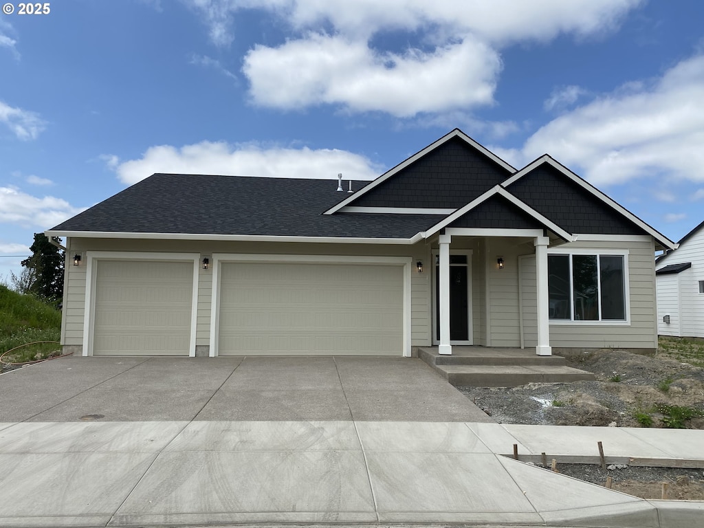 669 Parker Loop, Silverton, OR 97381 - view of front facade featuring a garage, driveway, and a shingled roof