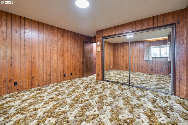 basement featuring carpet floors and wooden walls