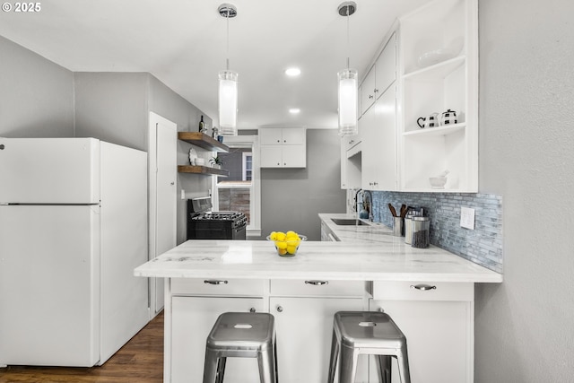 601 Mcclaine St, Silverton, OR 97381 - kitchen featuring freestanding refrigerator, open shelves, gas range oven, a peninsula, and white cabinets
