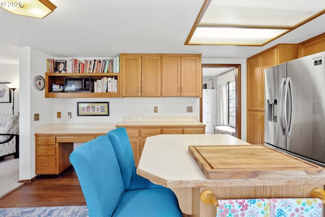 kitchen featuring tile counters, open shelves, stainless steel fridge with ice dispenser, and dark wood-style floors