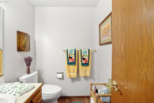 bathroom featuring toilet, wood finished floors, and vanity